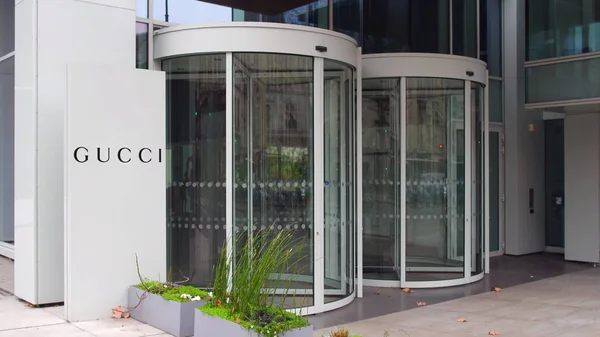 Straat signalisatie bord met Gucci logo. Modern kantoorgebouw. Redactioneel 3D-rendering — Stockfoto