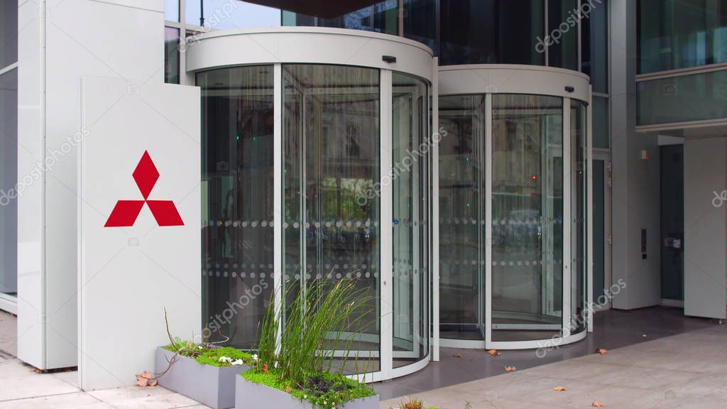 Street signage board with Mitsubishi logo. Modern office building. Editorial 3D United States