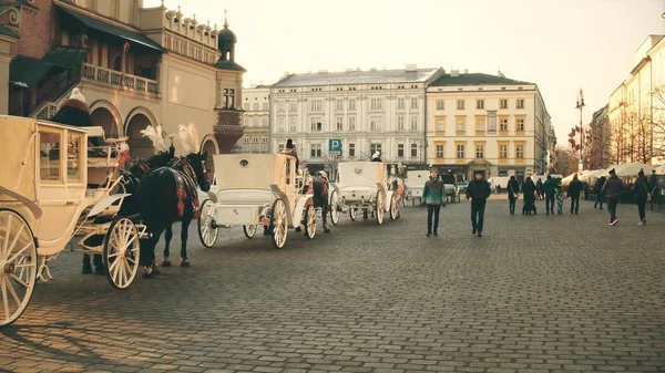 Krakow, Polen - januari 14, 2017 Retro häst dragna vagnar och gamla staden gatan, varma färger — Stockfoto