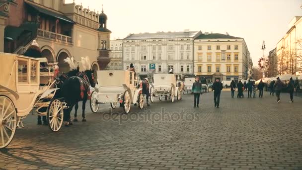 KRAKOW, POLONIA - ENERO, 14, 2017 Steadicam tiro de caballos retro carruajes tirados y la Navidad decorado calle del casco antiguo, colores cálidos. Vídeo 4K — Vídeos de Stock