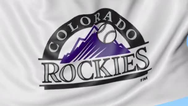 Gros plan du drapeau ondulé avec le logo de l'équipe de baseball Colorado Rockies MLB, boucle transparente, fond bleu. Animation éditoriale. 4K — Video