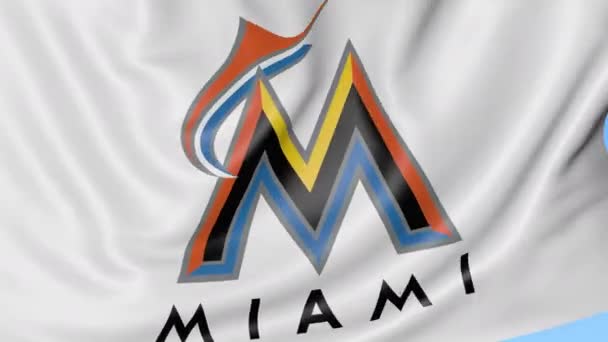 Primer plano de la bandera ondeante con el logotipo del equipo de béisbol Miami Marlins MLB, lazo sin costuras, fondo azul. Animación editorial. 4K — Vídeos de Stock