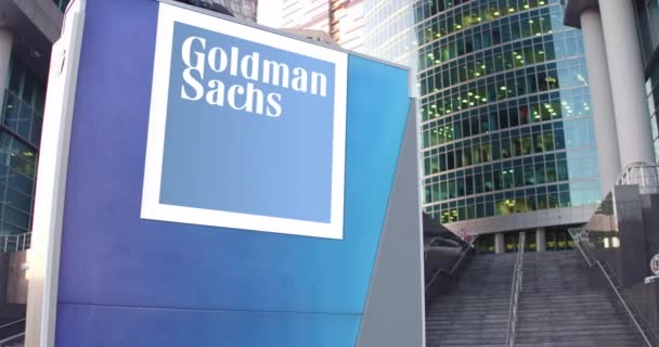 Straat signalisatie bord met het logo van Goldman Sachs Group, Inc. Moderne kantoor centrum wolkenkrabber en trappen achtergrond. Redactionele 3d rendering van 4k — Stockvideo