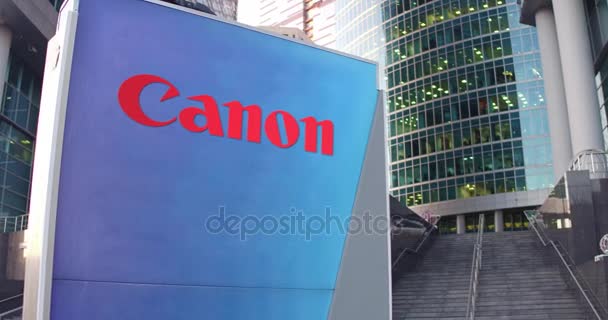 Papan nama jalan dengan logo Canon Inc.. Gedung kantor modern pencakar langit dan tangga latar belakang. Penyuntingan 3D render 4K — Stok Video