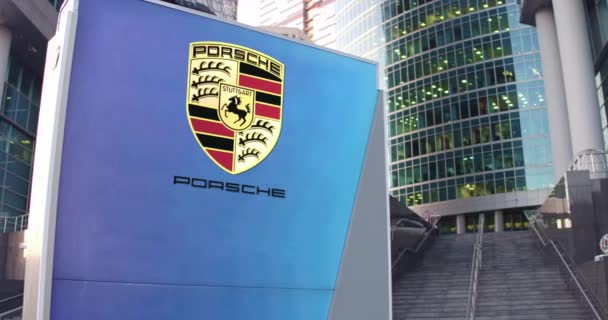 Tablero de señalización con logo Porsche. Rascacielos moderno centro de oficina y escaleras de fondo. Editorial 3D renderizado 4K — Vídeos de Stock