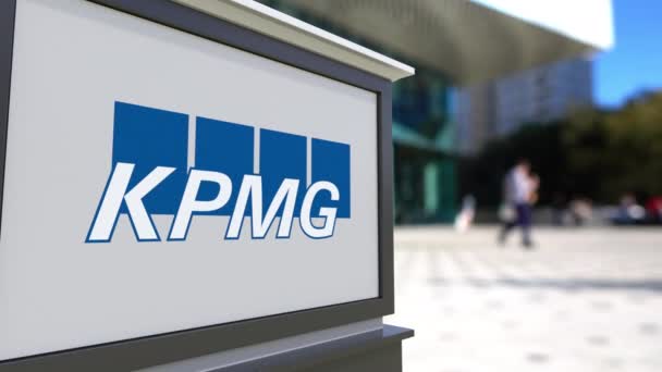 Placa de sinalização de rua com logotipo KPMG. Centro de escritórios desfocado e pessoas ambulantes fundo. Editorial 3D renderização 4K — Vídeo de Stock