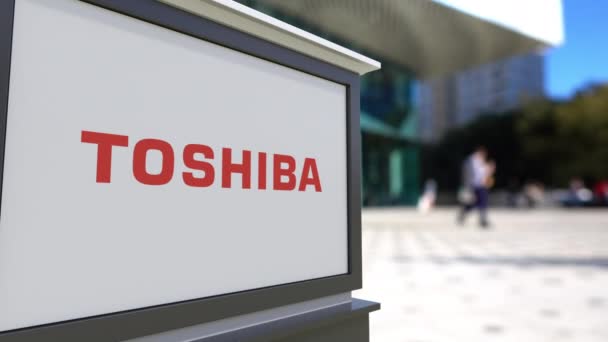 Σήμανση οδών σκάφους με λογότυπο Toshiba Corporation. Κέντρο θολή office και περπάτημα άτομα φόντο. Συντακτική 3d rendering 4k — Αρχείο Βίντεο