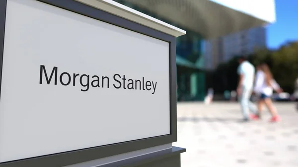 Tablero de señalización con el logotipo de Morgan Stanley Inc.. Centro de oficina borrosa y gente caminando fondo. Representación Editorial 3D —  Fotos de Stock