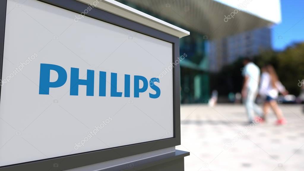 Street signage board with Philips logo. Blurred office center and walking people background. Editorial 3D United States