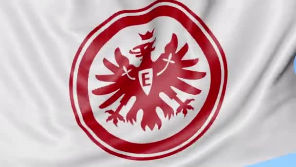 Primer plano de la bandera ondeante con el logotipo del club de fútbol Eintracht Frankfurt, lazo sin costuras, fondo azul. Animación editorial. 4K — Vídeos de Stock