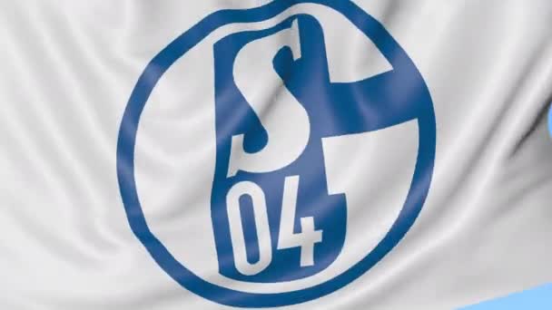 Gros plan du drapeau ondulé avec le logo du club de football FC Schalke 04, boucle transparente, fond bleu. Animation éditoriale. 4K — Video