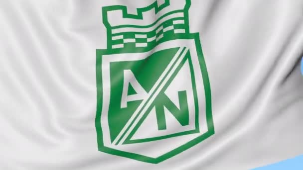 Close-up da bandeira acenando com o logotipo do clube de futebol Atlético Nacional, loop sem costura, fundo azul. Animação editorial. 4K — Vídeo de Stock