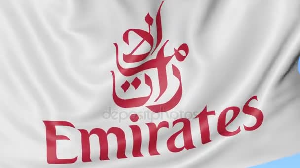 Primer plano de la bandera ondeante con el logotipo de Emirates Airline, bucle transparente, fondo azul, animación editorial. 4K ProRes — Vídeo de stock