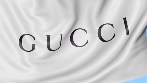 Primer plano de la bandera ondeante con el logotipo de Gucci, bucle sin costuras, fondo azul, animación editorial. 4K ProRes — Vídeos de Stock