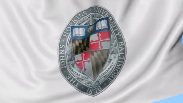 Close-up da bandeira acenando com o emblema da Universidade Johns Hopkins, loop sem costura, fundo azul. Animação editorial. 4K — Vídeo de Stock