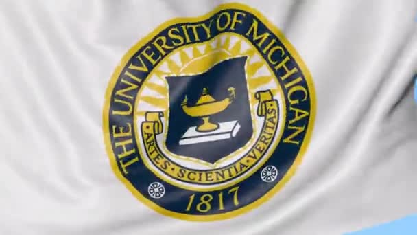 Primo piano della bandiera sventolante con emblema dell'Università del Michigan, anello senza cuciture, sfondo blu. Animazione editoriale. 4K — Video Stock