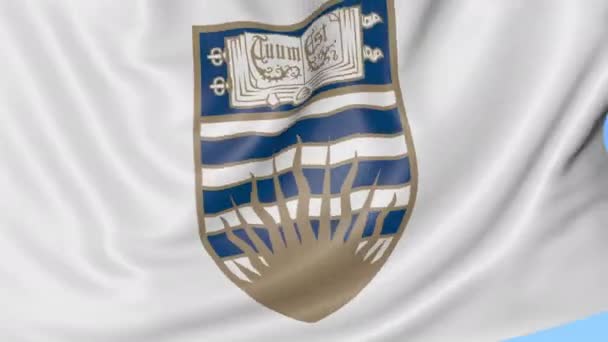 Primer plano de la bandera ondeante con emblema de la Universidad de Columbia Británica, lazo sin costuras, fondo azul. Animación editorial. 4K — Vídeos de Stock