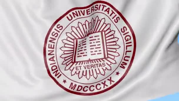 Close-up da bandeira acenando com o emblema da Universidade de Indiana, loop sem costura, fundo azul. Animação editorial. 4K — Vídeo de Stock