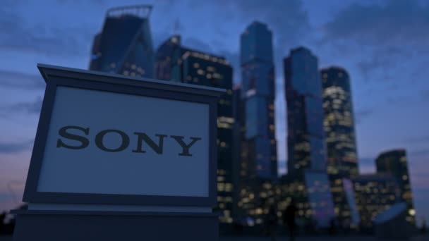 Street signage board with Sony Corporation logo in the evening.  Blurred business district skyscrapers background. Editorial 3D rendering 4K — Stock Video