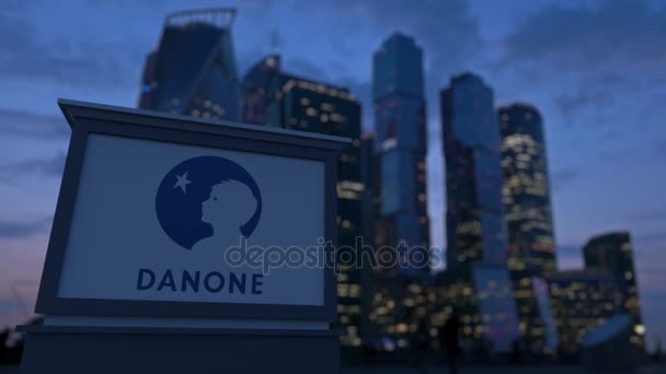 Utcai signage ellátás este Danone logóval. Üzleti negyed felhőkarcolók háttér életlen. Szerkesztői 3d rendering 4k — Stock videók