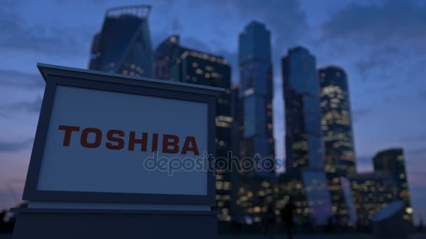 Panneau de signalisation avec logo Toshiba Corporation dans la soirée. Fond flou de gratte-ciel de quartier d'affaires. Editorial 3D rendu 4K — Video