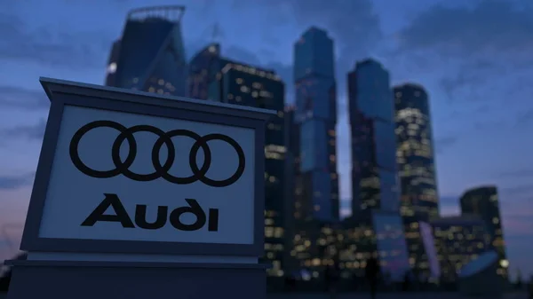 Utcai signage Kártya Audi logó az esti órákban. Üzleti negyed felhőkarcolók háttér életlen. Szerkesztői 3d-leképezés — Stock Fotó