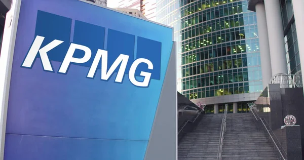 Tablero de señalización con el logotipo de KPMG. Rascacielos moderno centro de oficina y escaleras de fondo. Representación Editorial 3D — Foto de Stock