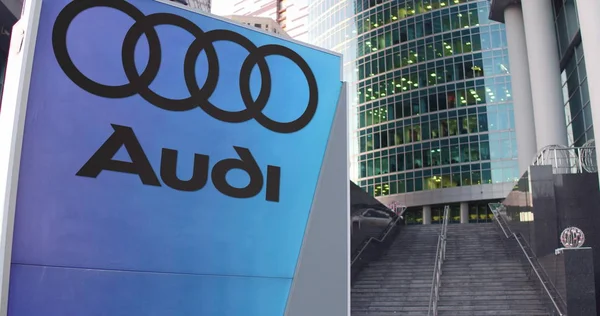 Tablero de señalización con logo Audi. Rascacielos moderno centro de oficina y escaleras de fondo. Representación Editorial 3D —  Fotos de Stock