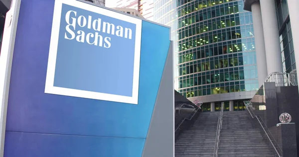 Cartelera de señalización con el logotipo de The Goldman Sachs Group, Inc.. Rascacielos moderno centro de oficina y escaleras de fondo. Representación Editorial 3D — Foto de Stock