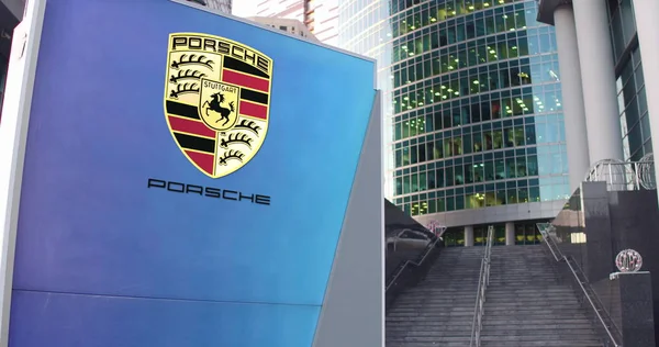 Tablero de señalización con logo Porsche. Rascacielos moderno centro de oficina y escaleras de fondo. Representación Editorial 3D —  Fotos de Stock
