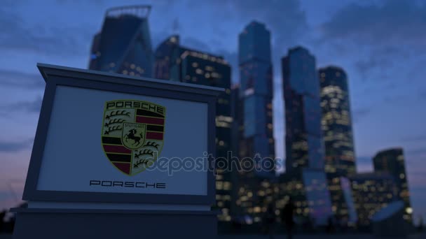 Вечером вывеска с логотипом Porsche. Размытые данные о небоскребах в деловом районе. 3D-рендеринг в 4K — стоковое видео