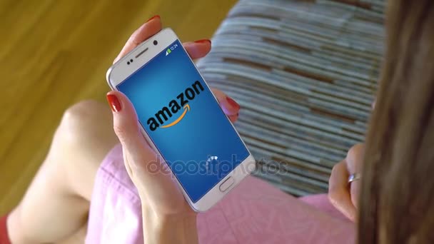 Fiatal nő gazdaság egy sejt telefon-val Amazon mobil app. konceptuális szerkesztői 4k klip betöltése — Stock videók