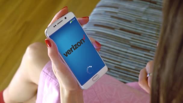 ベライゾン携帯アプリ コンセプチュアル編集 4 k クリップを読み込むと携帯電話を保持している若い女性 — ストック動画
