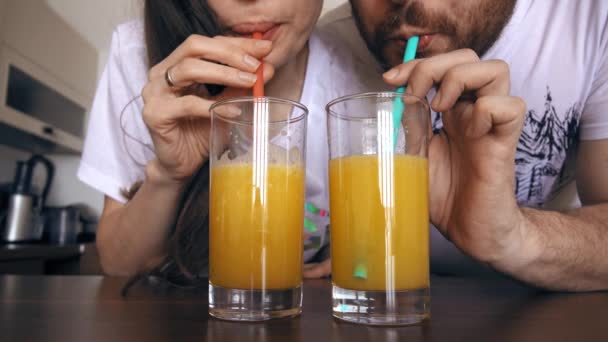 Fiatal nő és férfi ivás szalmaszál a narancslé. Egészséges életmód vagy vicces verseny fogalmak. 4 k-klip — Stock videók