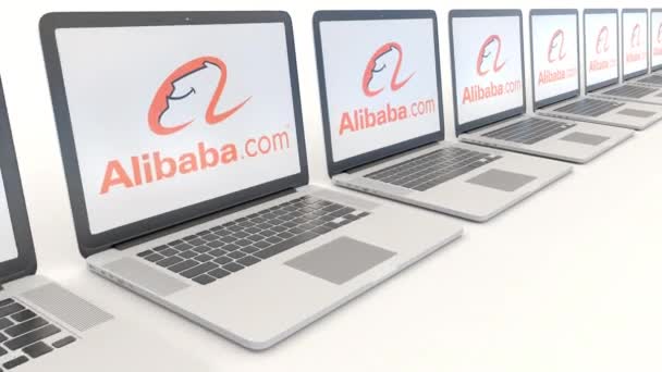 Современные ноутбуки с логотипом Alibaba.com. Концептуальная редакционная работа по компьютерным технологиям 4К клип, бесшовный цикл — стоковое видео