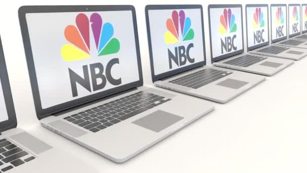 Computadoras portátiles modernas con logotipo de la National Broadcasting Company NBC. Tecnología informática editorial conceptual clip 4K, bucle sin costura — Vídeo de stock