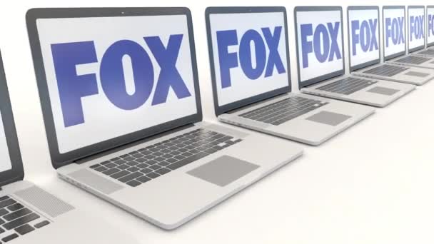 Portátiles modernos con logotipo Fox Broadcasting Company. Tecnología informática editorial conceptual clip 4K, bucle sin costura — Vídeo de stock