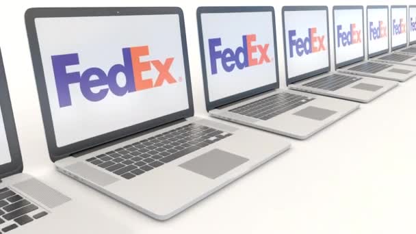 Moderní notebooky s Fedex logo. Počítač technika koncepční redakční 4k klip, bezešvé smyčka — Stock video