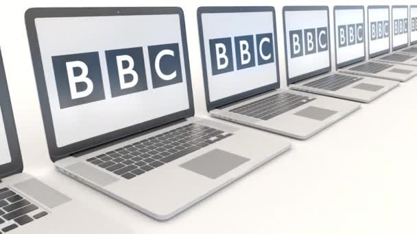 Computadoras portátiles modernas con logotipo de British Broadcasting Corporation BBC. Tecnología informática editorial conceptual clip 4K, bucle sin costura — Vídeos de Stock