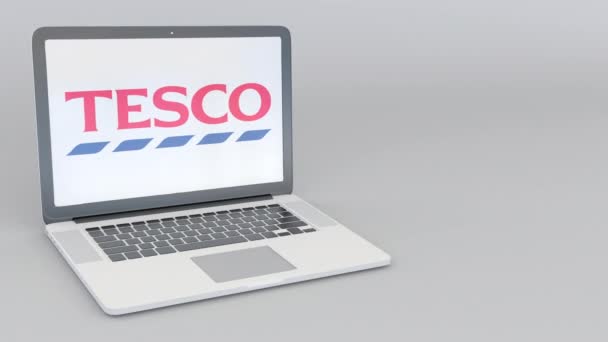 Rotativa de abertura e fechamento de laptop com logotipo da Tesco. Tecnologia de computador editorial conceitual 4K clip — Vídeo de Stock