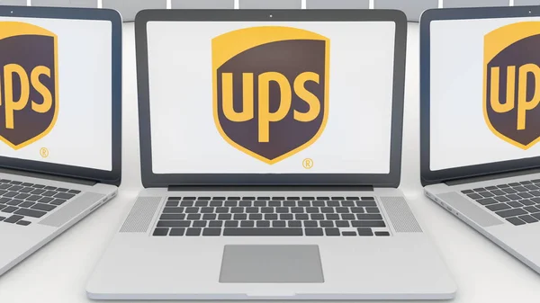 Laptopuri cu logo-ul United Parcel Service UPS pe ecran. Tehnologia computerului redarea 3D editorială conceptuală — Fotografie, imagine de stoc