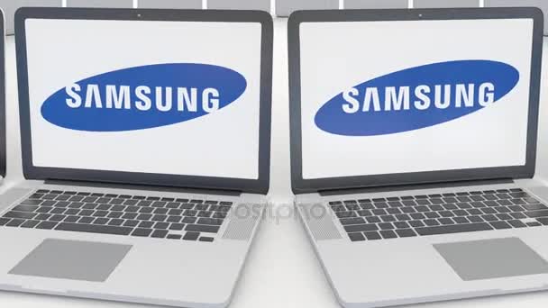 Portátiles con el logotipo de Samsung en la pantalla. Tecnología informática editorial conceptual clip 4K, bucle sin costura — Vídeo de stock