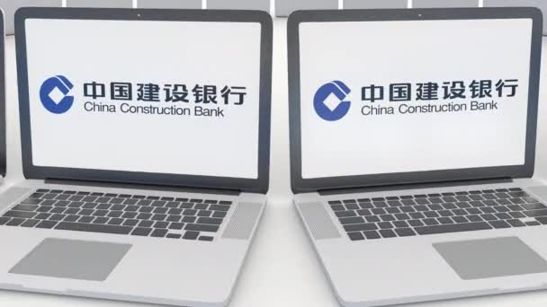 Portátiles con el logotipo del Banco de Construcción de China en la pantalla. Tecnología informática editorial conceptual clip 4K, bucle sin costura — Vídeo de stock