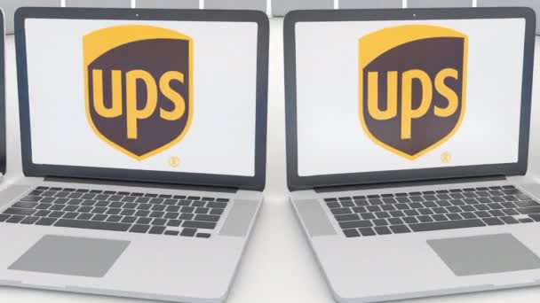 Dizüstü bilgisayarlar ile Birleşik parsel Ups hizmeti logo üstünde belgili tanımlık perde. Bilgisayar teknolojisi kavramsal editoryal 4k klip, sorunsuz döngü — Stok video