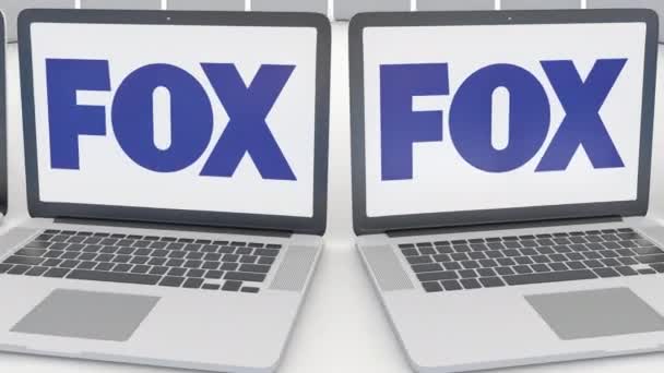 Laptops com logotipo Fox Broadcasting Company na tela. Tecnologia de computador editorial conceitual clipe 4K, loop sem costura — Vídeo de Stock