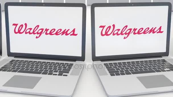 Portátiles con logotipo de Walgreens en la pantalla. Tecnología informática editorial conceptual clip 4K, bucle sin costura — Vídeos de Stock