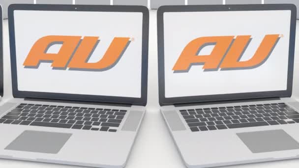 Ноутбуки с логотипом компании Au Mobile на экране. Концептуальная редакционная работа по компьютерным технологиям 4К клип, бесшовный цикл — стоковое видео