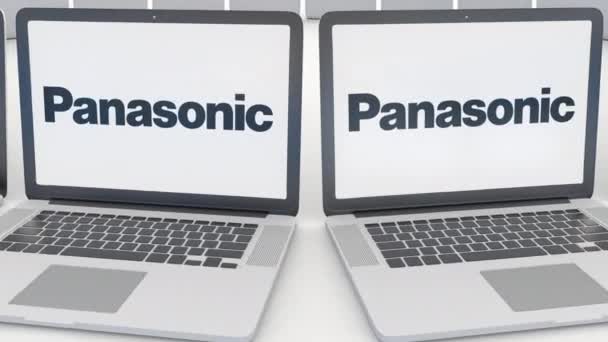Panasonic Corporation logo üstünde belgili tanımlık perde ile dizüstü bilgisayarlar. Bilgisayar teknolojisi kavramsal editoryal 4k klip, sorunsuz döngü — Stok video
