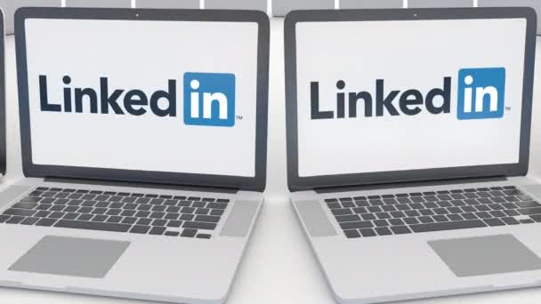 Portátiles con logotipo de LinkedIn en la pantalla. Tecnología informática editorial conceptual clip 4K, bucle sin costura — Vídeo de stock