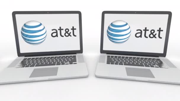 Amerikan telefon ve telgraf şirketi, T logo üstünde belgili tanımlık perde ile dizüstü bilgisayar. Bilgisayar teknolojisi kavramsal editoryal 4k klip, sorunsuz döngü — Stok video